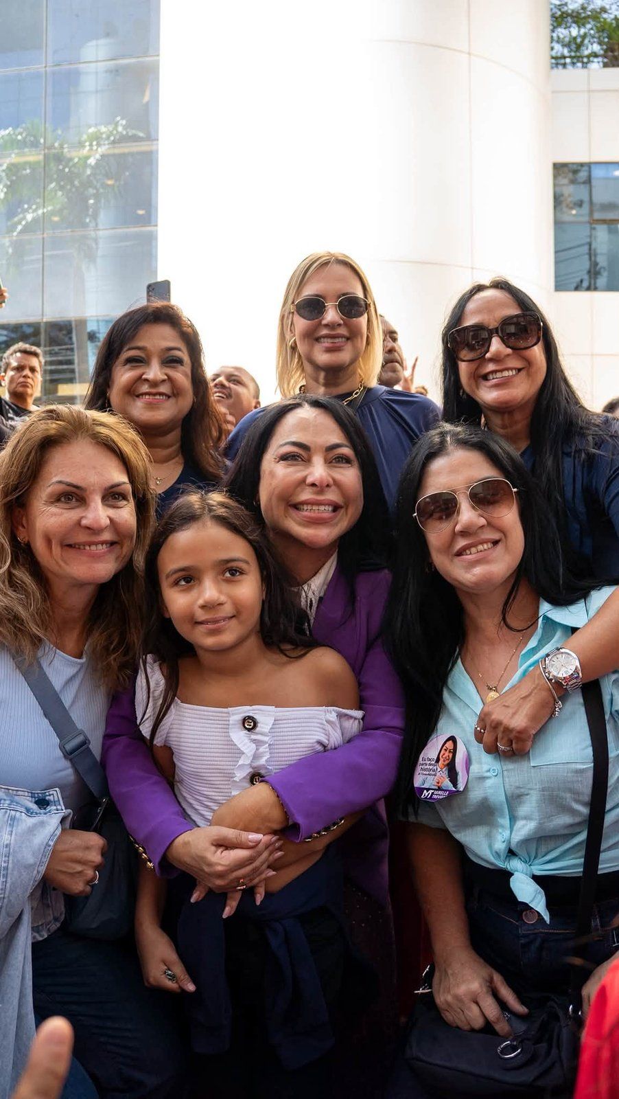 Mirelle Trevisan aparece em uma fotografia de grupo com mulheres e uma criança.